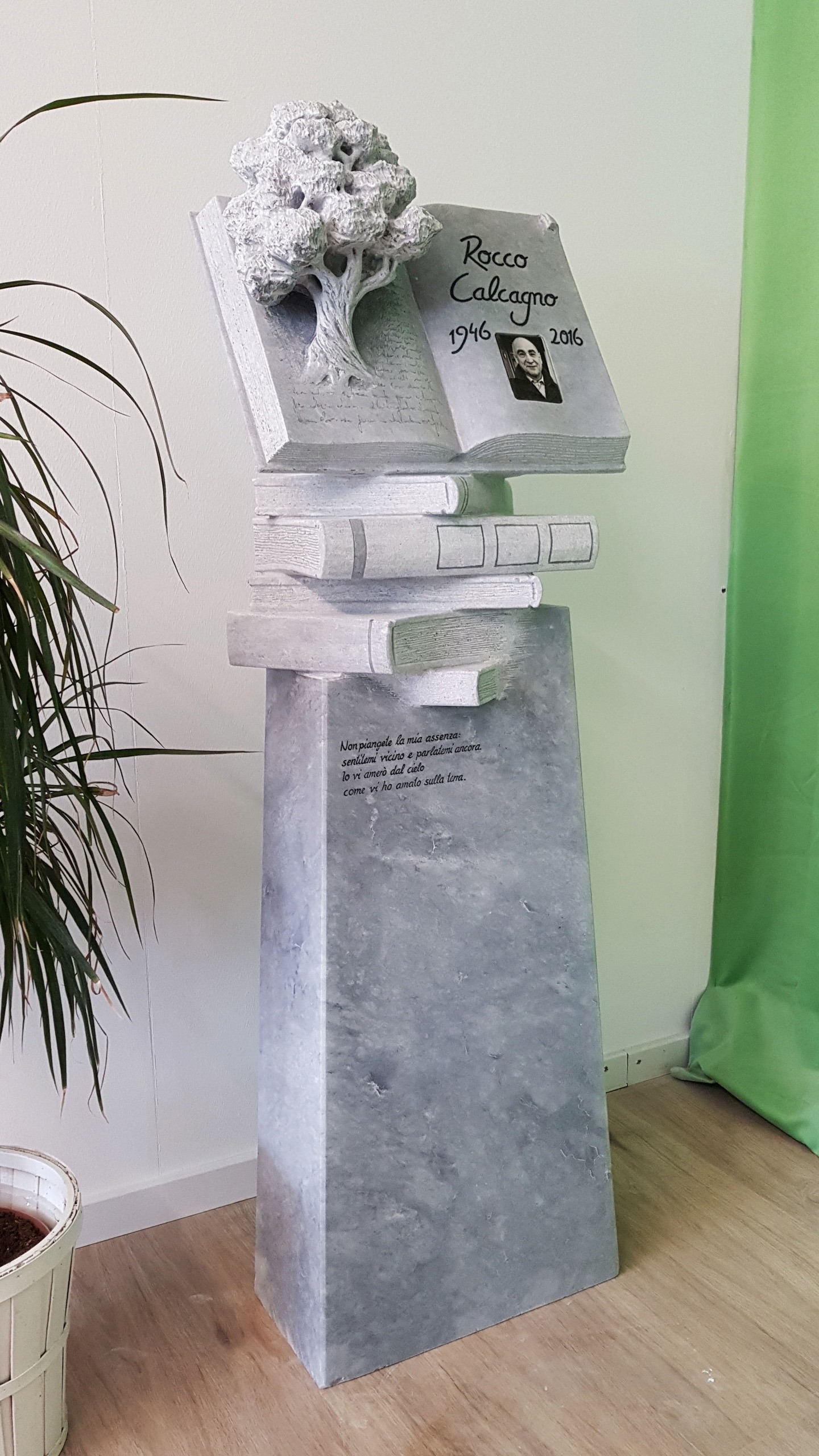 Individuelle Grabmalkunst, Grauer schöner Grabstein mit zahlreichen Büchern und einem wunderschönen aus dem Buch wachsenden Baum mit Foto des Verstorbenen, handgefertigt von der Bildhauerei Sini in Grenchen, Seitenansicht